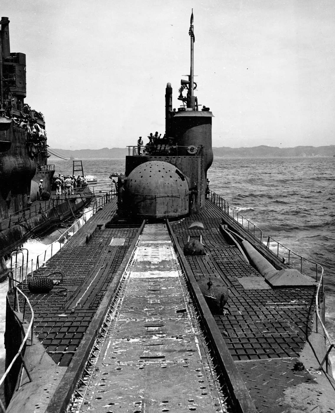 A black-and-white photograph showing the Japanese submarines I-14 and I-400 anchored side by side in Sagami Bay on September 25, 1945, following Japan’s surrender. The I-14 appears in the foreground with the much larger I-400 visible to the left. Both submarines feature the distinctive cylindrical aircraft hangars and large conning towers associated with Japan’s I-class designs. These vessels were capable of carrying Aichi M6A Seiran floatplanes for reconnaissance and attack missions. The image captures the scale and engineering ambition of Japan’s submarine aircraft carriers, which combined underwater stealth with long-range airpower.