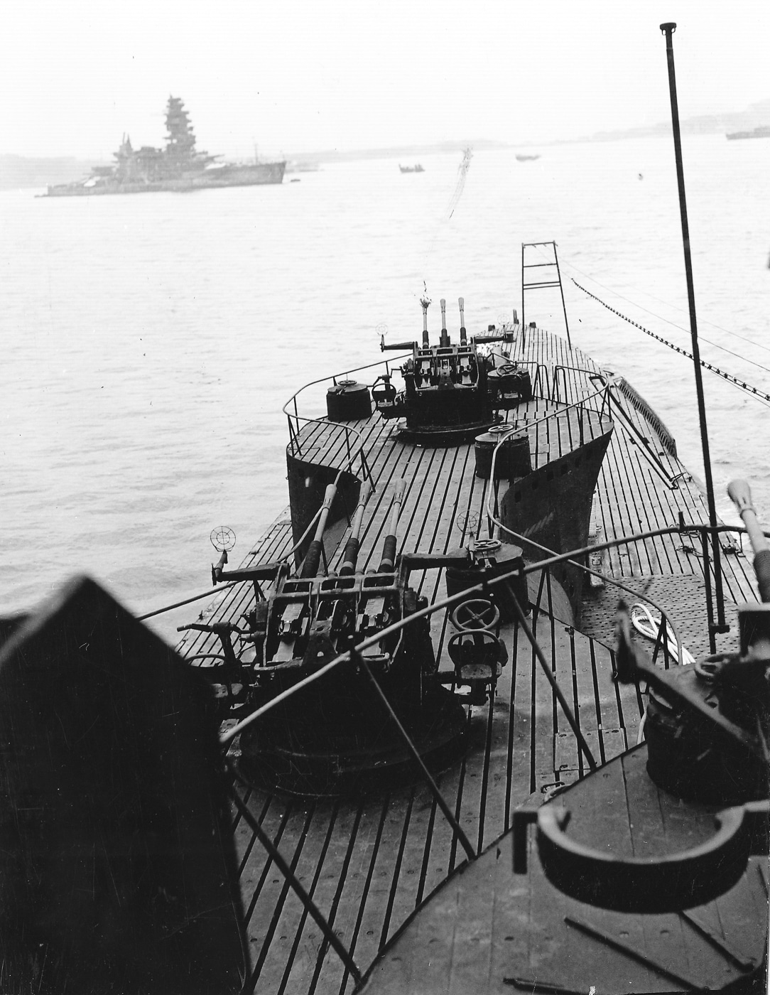 A detailed wartime photograph showing the rear section of the Imperial Japanese Navy submarine I-401, focusing on the anti-aircraft weapons mounted behind the aircraft hangar. Two triple 25mm Type 96 autocannons are clearly visible, with an additional single 25mm gun to the right. These mounts were positioned to provide all-around air defense when the submarine operated on the surface. The I-401, part of the I-400 class, was an aircraft-carrying submarine capable of launching Aichi M6A Seiran bombers. The image highlights the combination of offensive and defensive systems integrated into Japan’s largest submarines.