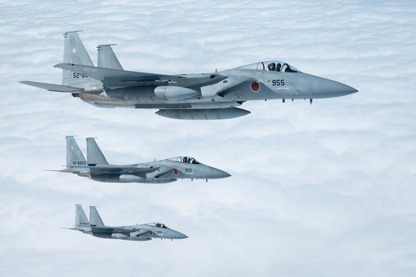 Three Japan Air Self-Defense Force F-15J Eagles are seen flying in close formation with a U.S. Air Force KC-135 Stratotanker over the Pacific Ocean on December 14, 2022. The Stratotanker, assigned to the 909th Air Refueling Squadron, provides aerial refueling support as part of ongoing U.S.-Japan defense cooperation. The image captures the sleek design of the F-15J fighters as they maintain precise formation beside the larger refueling aircraft. This joint mission symbolizes the strength of the U.S.-Japan Alliance, which underpins regional stability in the Indo-Pacific. The blue ocean and clear sky emphasize the operational reach and readiness of both air forces. The photograph highlights how training missions like this one ensure interoperability and preparedness for real-world operations.