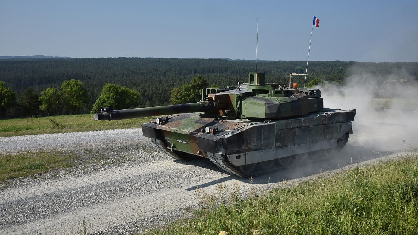 A general overview image of a Leclerc tank used as the lead photo in an article. The tank is shown with its signature 120mm gun extended forward and a low turret that houses the commander and gunner. Its compact design highlights France’s emphasis on speed and maneuverability in tank doctrine. The armor modules are visible along the hull and turret sides. The vehicle’s size and silhouette are noticeably smaller than other NATO tanks. The photograph serves to set the stage for a detailed discussion of the Leclerc’s history, design, and modernization.