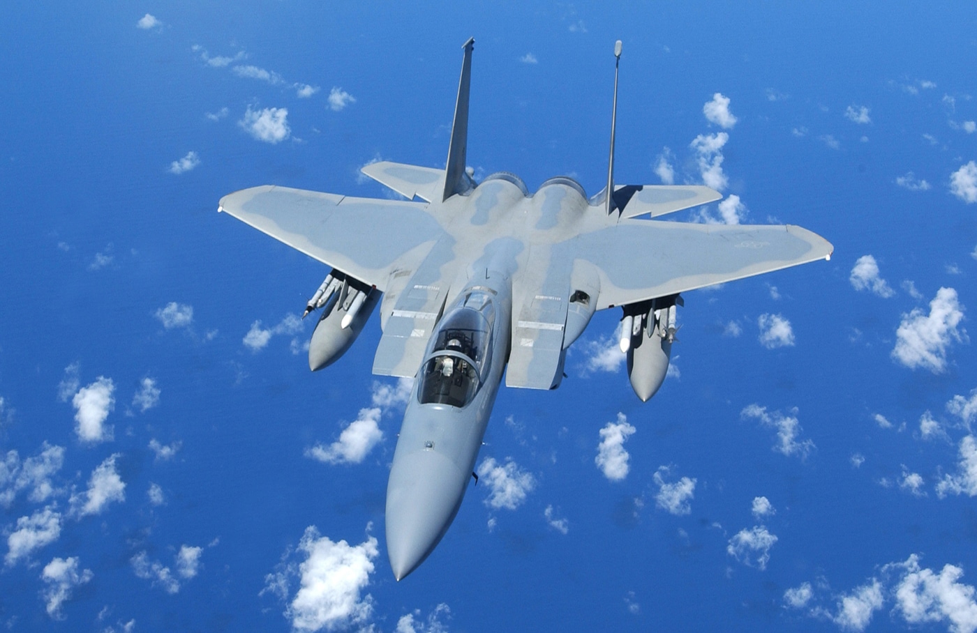 A U.S. Air Force F-15C Eagle from the 44th Fighter Squadron prepares for aerial refueling behind a KC-135 Stratotanker from the 909th Air Refueling Squadron during Exercise Beverly High 06-03 on September 12, 2006. The scene takes place above Kadena Air Base, Japan, where the Eagle aligns with the refueling boom extended from the tanker. The photo highlights the precision and coordination required for midair refueling operations. The F-15C’s twin vertical stabilizers and swept wings are visible as it maintains steady formation. This training enhances mission readiness and endurance for both aircrews. The exercise is part of ongoing efforts to strengthen U.S. airpower capability in the Indo-Pacific region.