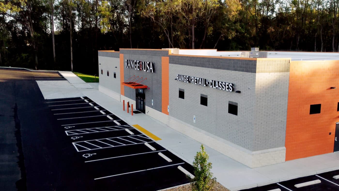 Exterior view of a recently opened Range USA building featuring the company’s recognizable logo and modern design. The photo shows a clean, well-maintained parking lot and clear signage welcoming visitors. The structure is brightly lit and built with the same consistent, professional look found across Range USA locations nationwide. The image reflects the brand’s commitment to accessibility and community. Range USA facilities are known for offering firearm rentals, training programs, and a full retail experience under one roof. This new site represents the continued expansion of the largest indoor shooting range operator in the United States.