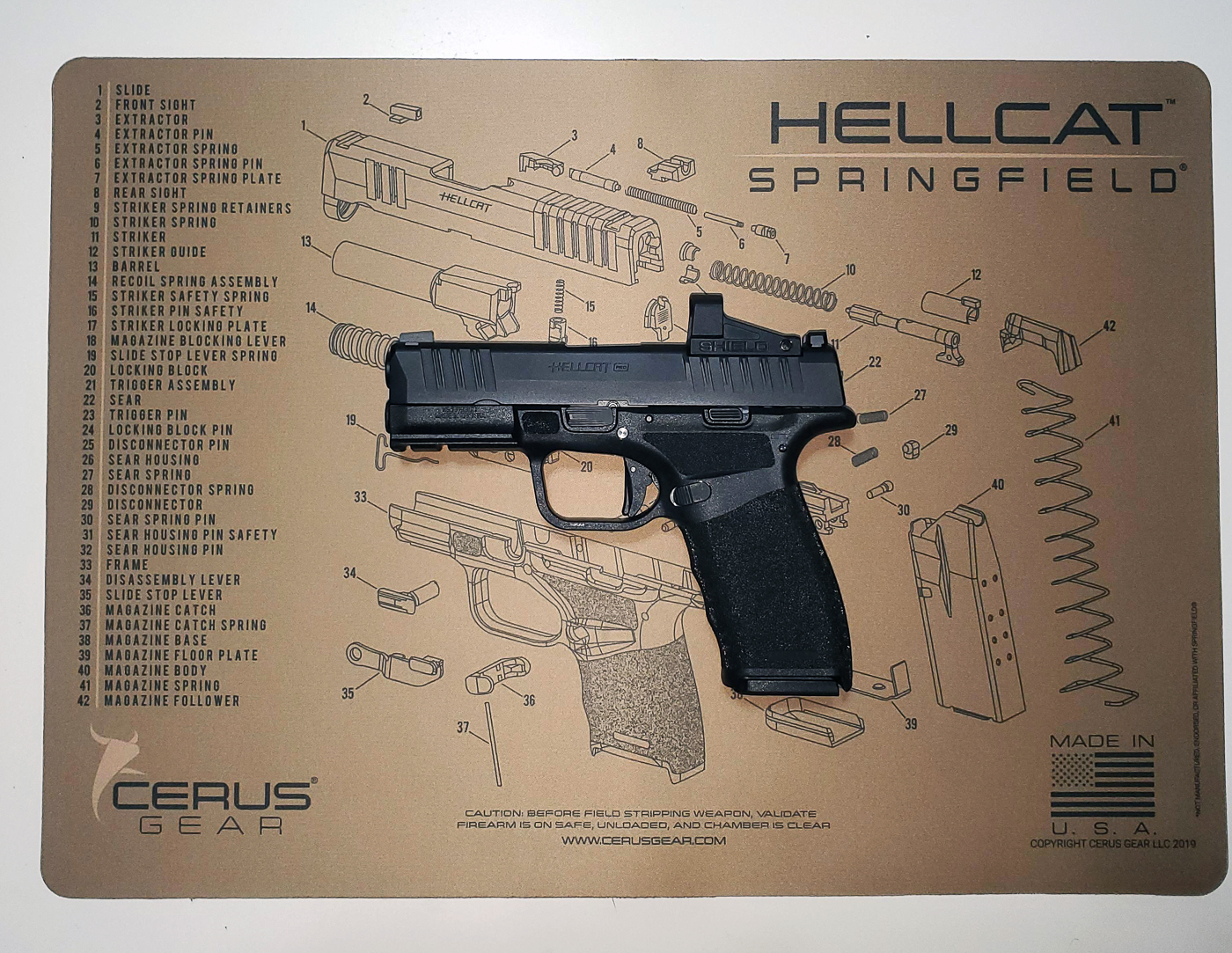 A Springfield Armory Hellcat compact concealed carry pistol photographed as the firearm used for testing paddle holsters. The Hellcat features a slim frame and ergonomic grip designed for everyday carry. This particular model includes an optics-ready slide, making it compatible with red dot sights for faster target acquisition. During paddle holster testing, the Hellcat’s size and weight proved to be a good match for outside-the-waistband carry with a paddle attachment. The pistol is known for its high capacity in a micro-compact platform, which has made it one of Springfield’s most popular models. Keywords: Springfield Armory Hellcat, concealed carry pistol, paddle holster test gun, compact handgun, optics-ready carry pistol. The image highlights the firearm chosen for holster demonstrations and evaluation.