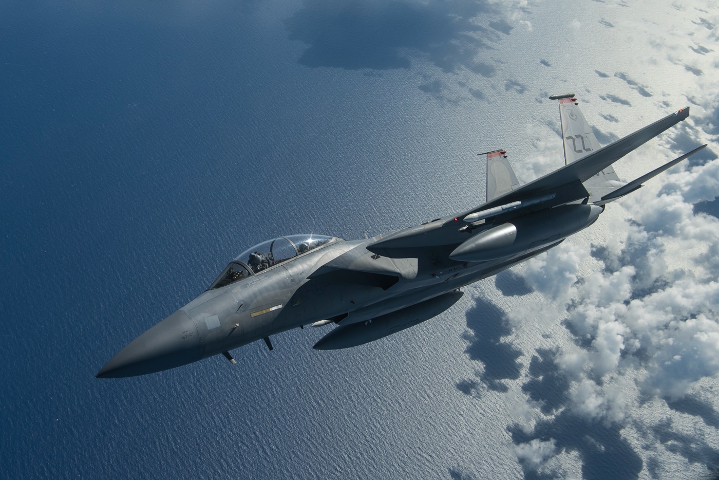 A U.S. Air Force F-15D Eagle is photographed in flight over the Mariana Islands on September 18, 2018, during Exercise Valiant Shield 18. The twin-seat fighter is shown from above, gliding through clear skies over the Pacific Ocean. Valiant Shield is a large-scale, joint training exercise that integrates U.S. Air Force, Navy, Marine Corps, and Army forces operating in the Indo-Pacific region. The F-15D’s sleek gray airframe, twin tails, and aerodynamic wings are clearly visible against the tropical backdrop. This photo highlights the aircraft’s speed, agility, and ability to support multi-branch combat operations. The exercise underscores U.S. readiness to project airpower and maintain stability across the Pacific. The image captures both the beauty of the region and the precision of modern air operations.