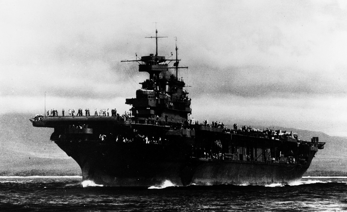 This photo shows USS Enterprise (CV-6) cruising at sea in March 1944 as a unit of the First Carrier Task Force in the Pacific. The carrier is flanked by other warships, including cruisers and destroyers, all moving in formation. The image illustrates the evolution of U.S. Navy strategy to concentrate multiple carriers in powerful task forces. Aircraft are visible on the flight deck, ready for rapid deployment. The sea is relatively calm, with the fleet stretching into the horizon. This era marked a new phase in the Pacific campaign, with coordinated strikes across wide distances. USS Enterprise’s participation in these formations underscored her ongoing importance despite being one of the oldest carriers in the fleet.