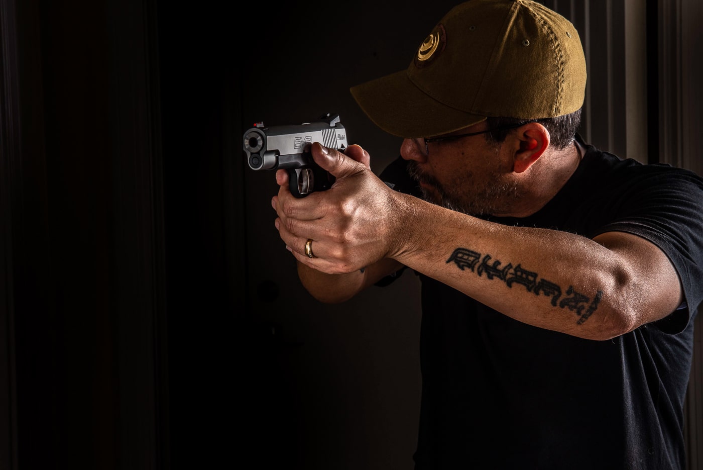 This image depicts a person drawing a handgun from a seated position in their vehicle, emphasizing the need for realistic self-defense training in diverse environments. The setting reinforces the article’s message about adapting skills to meet the challenges of sudden, close-quarters threats such as carjackings. Safe handling and awareness are evident, reflecting the mental and physical preparation recommended for surviving a gunfight. The scene is designed to illustrate practical considerations for self-protection, including drawing from concealment while restricted by seat belts and vehicle interiors. Consistent, scenario-based practice is suggested for anyone interested in developing the competence needed for personal safety. The action in the photo aligns with the broader themes of mental fortitude and readiness under pressure. The image is suitable for content discussing effective survival tactics in unpredictable situations.