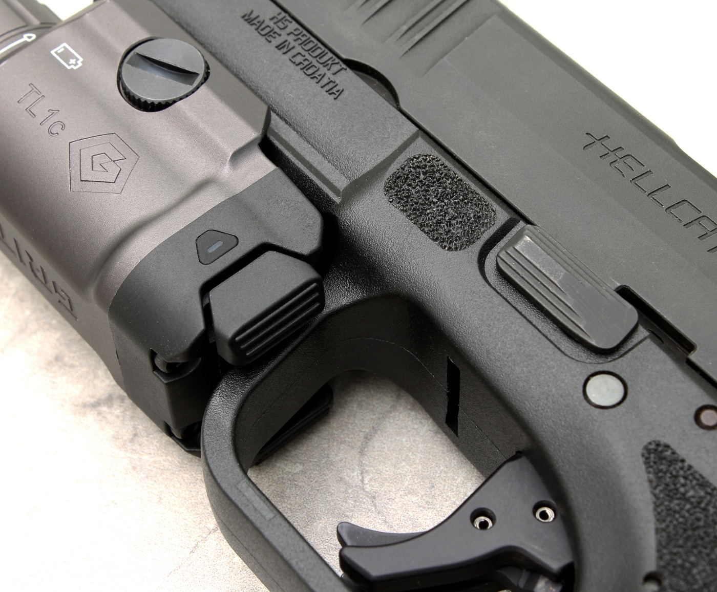 The GRITR TL1c features ambidextrous activation buttons for fast, intuitive use from either hand. This design suits both right- and left-handed shooters in defensive scenarios. Close-up photo of the GRITR TL1c weapon light’s activation buttons, demonstrating their ambidextrous placement and ease of use. Both the left and right sides of the unit have identical, textured switches that can be easily engaged with either the weak-hand thumb or the dominant hand’s index finger. The buttons are slightly raised for tactile feedback, allowing for fast operation in low-light or high-stress situations. The image highlights the user-focused design discussed in the review, emphasizing accessibility for all shooters regardless of hand dominance. The finish and construction around the controls are smooth and sturdy.