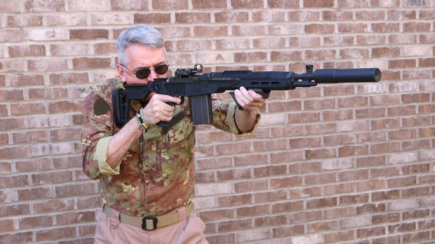 Author Will Dabbs firing Springfield Armory M1A SOCOM rifle equipped with Delta 14 Chassis Gen 2 during range evaluation demonstrating real-world performance of the lightweight polymer system. The glass-filled nylon construction weighs only 0.75 pounds yet withstands the substantial recoil generated by the 7.62 NATO cartridge. The chassis design optimizes ergonomics through careful geometric engineering that provides natural cheekweld and comfortable shooting positions. Visible recoil management demonstrates how the system's efficient design mitigates felt kick from the powerful .308 Winchester ammunition. The M-Lok accessory mounting points along the forend remain secure under firing stress. Heat-resistant properties of the DuPont Zytel material prevent uncomfortable temperature buildup during sustained shooting sessions. Range testing confirms the chassis maintains accuracy and zero while dramatically reducing overall rifle weight compared to traditional configurations.