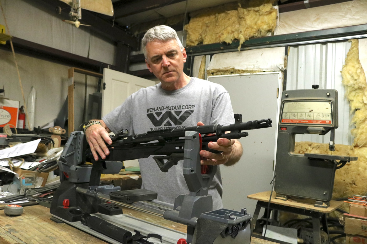 Author completing Delta 14 Chassis Gen 2 installation on Springfield Armory M1A SOCOM rifle showing final assembly stage with trigger group reinstallation in workshop setting. The tight fit between fire controls and chassis ensures no play or movement that could affect accuracy or reliability during shooting. Glass-filled nylon construction visible throughout the chassis system demonstrates the lightweight yet durable material selection. M-Lok accessory slots along forend remain accessible for tactical equipment mounting after installation is complete. Flared magwell design improves magazine insertion ergonomics with 20-round detachable boxes. Steel front ferrule and rear T-nut mount provide critical reinforcement at high-stress points while keeping overall chassis weight to 0.75 pounds. Installation requires no gunsmithing expertise or permanent firearm modifications allowing return to factory configuration if desired. The completed assembly transforms the traditional M1A platform into a modern tactical rifle maintaining full 7.62 NATO power and proven gas-operated reliability.