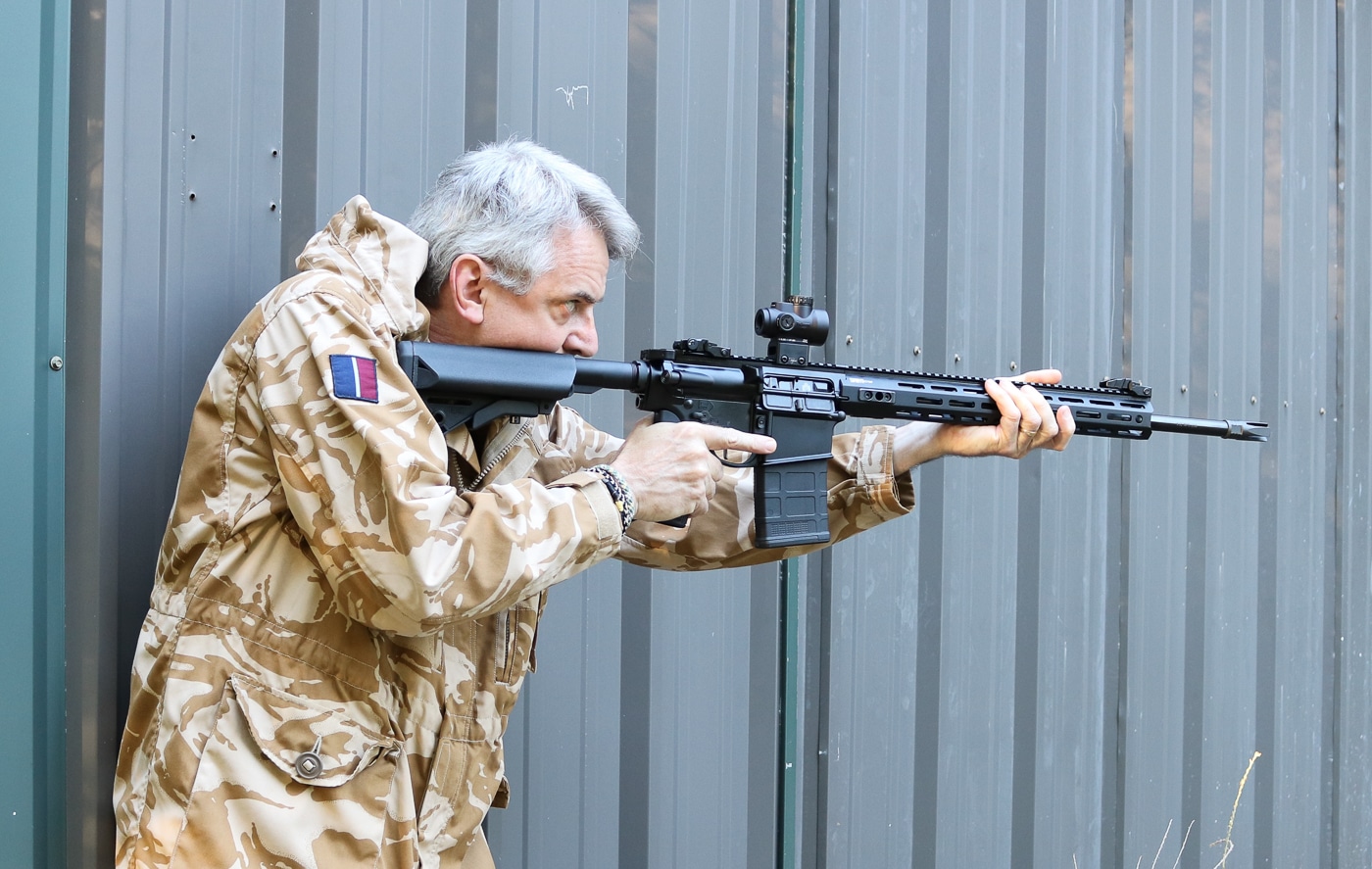 A shooter is pictured firing a Springfield Armory SAINT AR-10 rifle outdoors. The shooter maintains a solid stance and proper shoulder placement, demonstrating control over the rifle’s recoil. The AR-10’s black finish, rail system, and adjustable stock are clearly visible in the frame. The background shows an open outdoor range, emphasizing real-world shooting conditions. The rifle’s design allows for smooth operation and effective recoil management despite its .308 chambering. Lighting and focus draw attention to the rifle and shooter interaction. This photo highlights the AR-10’s balance, ergonomics, and consistent performance under live-fire use.