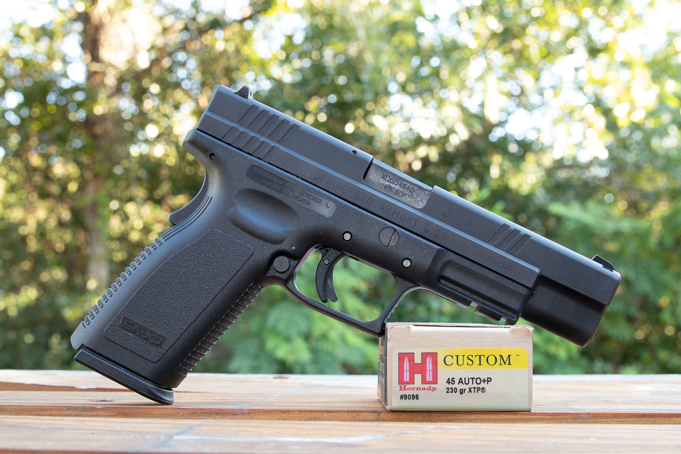Photograph displaying Springfield XD pistol in 45 ACP caliber with Hornady Custom XTP ammunition for defensive shooting and range testing purposes. Shooters must test different ammunition types in their specific firearms to determine reliable performance and accuracy. Hornady XTP hollow point bullets provide consistent expansion in both standard pressure and plus P overpressure loadings. Individual handguns perform differently with various ammunition brands and bullet weights requiring actual testing. The XD pistol represents modern firearms from major manufacturers rated for plus P higher pressure ammunition. Testing carry ammunition in defensive pistols reveals point of impact and reliability with specific loads. Hornady Custom ammunition offers quality jacketed hollow points for self-defense and practice applications. Firearm owners benefit from range sessions testing multiple ammunition types to find optimal performance in their guns.