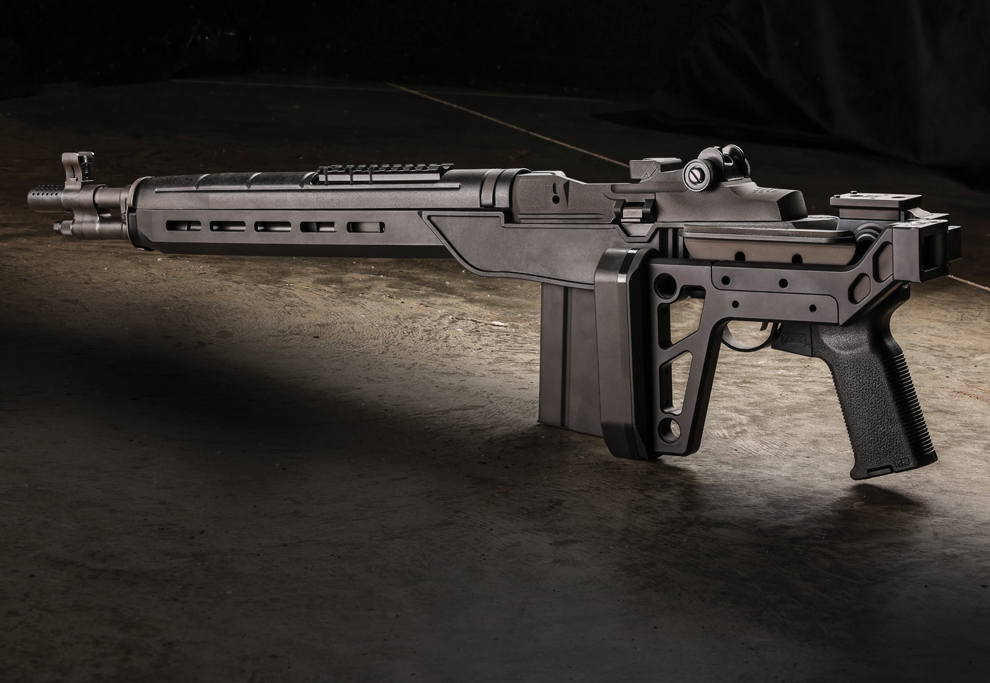 Springfield Armory M1A SOCOM rifle equipped with Delta 14 Chassis Gen 2 system showing the refined second-generation design released in 2018. The glass-filled nylon chassis weighs only 0.75 pounds compared to the 1.25-pound Gen 1 predecessor representing significant weight reduction while improving durability. DuPont Zytel composite material provides automotive-grade strength and environmental resistance through injection-molded construction. M-Lok accessory slots along the forend allow mounting of lights, lasers, and grips for tactical applications. Flared magwell design facilitates rapid magazine changes with 20-round detachable boxes during shooting. Steel front ferrule and rear T-nut mount ensure structural integrity at critical stress points despite lightweight polymer construction. Mossberg 500 pattern rear mount accepts wide variety of buttstock options from pistol grips to folding assemblies. The $199.99 base chassis price point makes M1A modernization accessible to average shooters seeking improved portability.