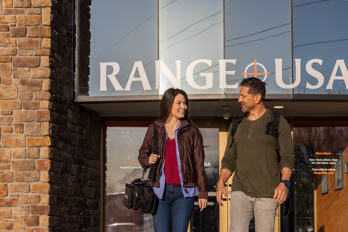 Photo of several customers walking out of a Range USA facility after completing an afternoon of indoor shooting. The group appears relaxed and satisfied, some carrying range bags or safety gear. The building exterior is clean and well-lit, displaying clear Range USA signage above the entrance. The lighting suggests late afternoon, and the parking area is visible in the background. The image communicates the positive, community-oriented atmosphere Range USA promotes across all its locations. It highlights the company’s commitment to providing safe, enjoyable, and well-managed shooting experiences for everyone.