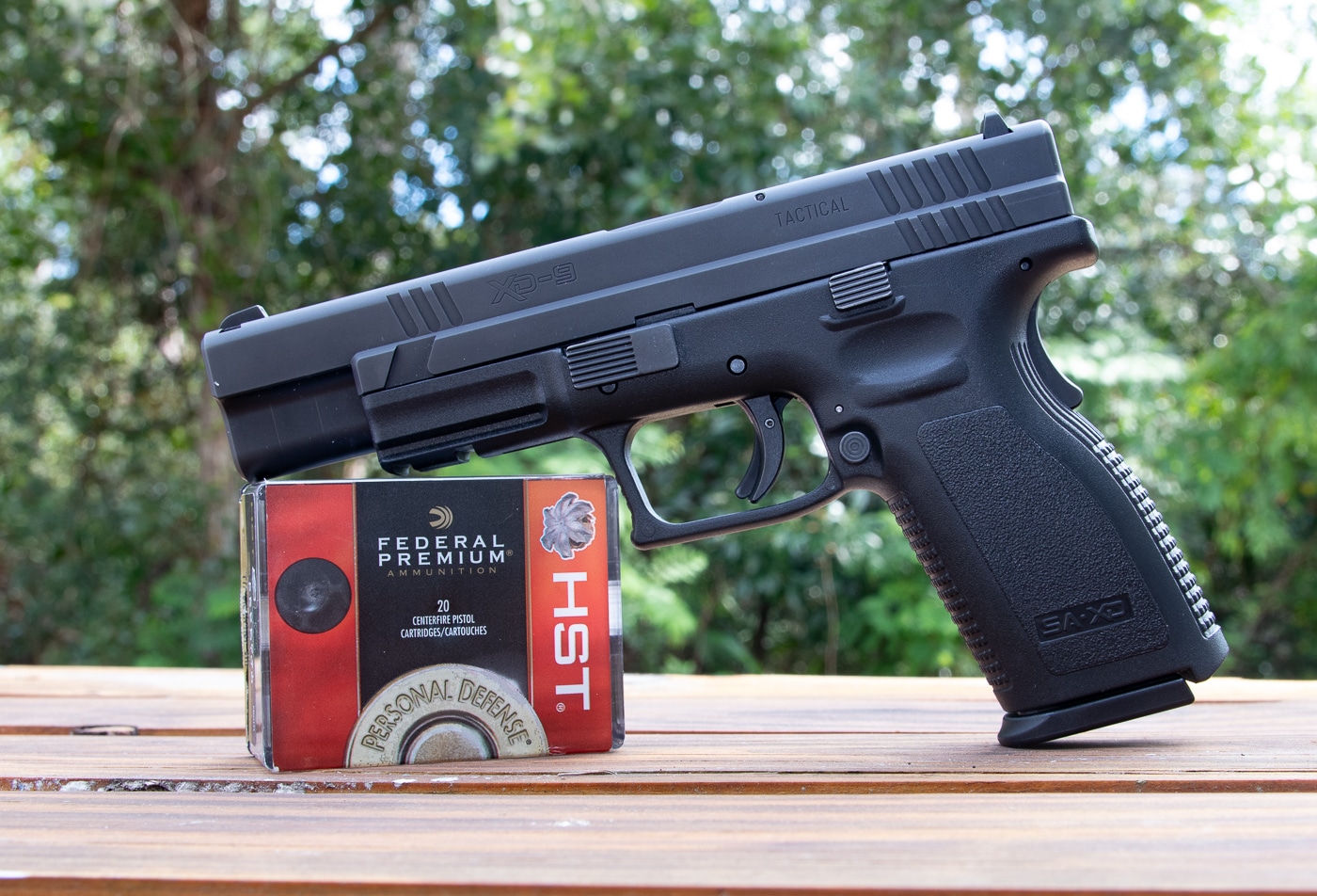 Springfield Armory XD9 Tactical pistol displayed with Federal HST 9mm hollow point ammunition showing different bullet weights for self defense applications. The handgun and defensive rounds illustrate the importance of choosing appropriate grain weight ammunition for concealed carry purposes. Federal HST represents premium self defense ammunition known for reliable expansion and penetration across various bullet weights including 115 grain, 124 grain, and 147 grain options. Selecting proper bullet weight for self defense requires understanding how grain weight affects terminal ballistics, recoil management, and barrier penetration in defensive shooting scenarios. The XD9 Tactical demonstrates a full-size service pistol platform that generates optimal velocities for hollow point expansion regardless of bullet weight selection. Quality defensive ammunition and reliable handguns form the foundation of effective concealed carry preparation. Understanding bullet grain weight helps shooters make informed decisions about self defense ammunition performance. Modern jacketed hollow point bullets like Federal HST deliver consistent results across multiple bullet weights when properly matched to the carry gun.