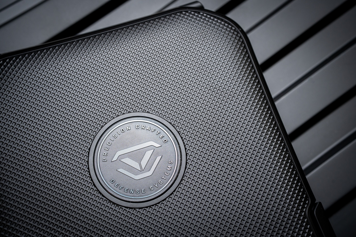 Close-up image showing the exterior surface texture of the Vaultek Lifepod 20 Biometric safe. The polymer shell has a matte finish with a fine-textured treatment that provides grip and scratch resistance. Subtle ridges and lines along the lid reinforce the case’s rugged design while keeping the overall look modern and minimalistic. The finish reduces fingerprints and smudges, making the safe appear clean even after regular handling. The photo emphasizes the durability of the T3 polymer construction, which is impact-tested, dustproof, and waterproof. This textured treatment is a defining characteristic that balances utility with professional styling, showing the Lifepod’s role as both a firearm safe and travel lockbox.