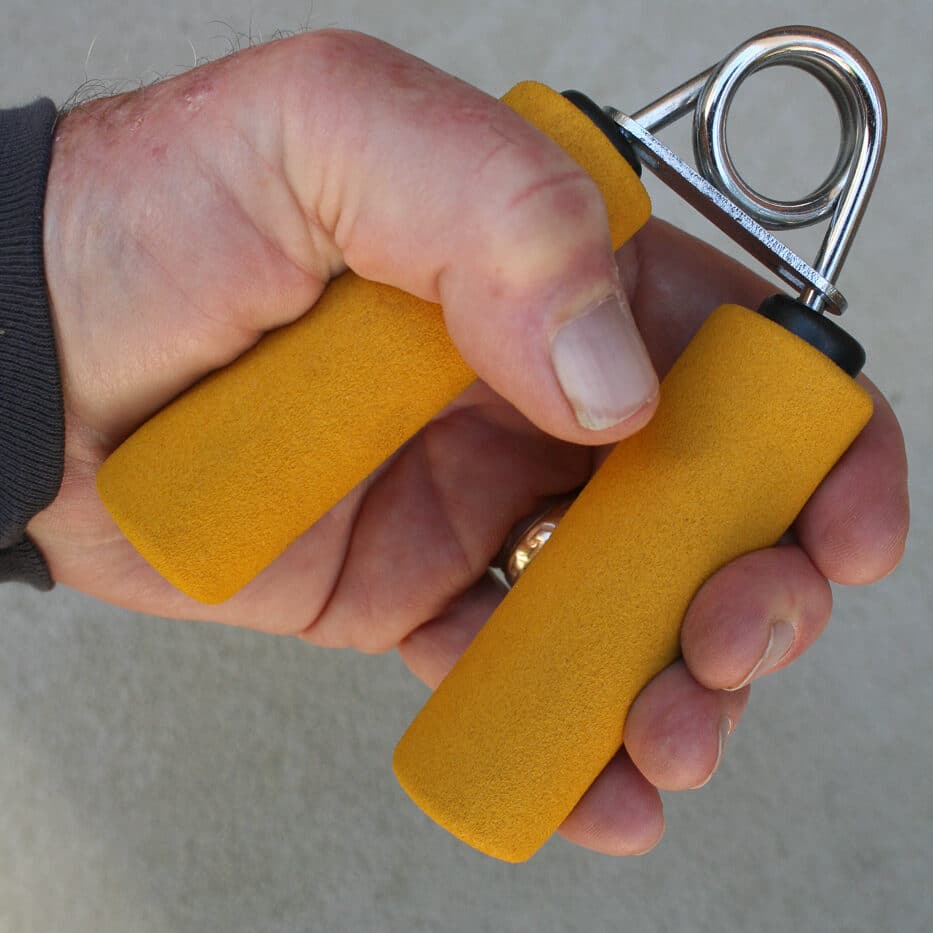 Photograph showing hand grip strength training equipment used to improve shooting performance and pistol control. The image demonstrates tools like spring-loaded hand exercisers or polymer grip balls that shooters can use to develop stronger hands. Maintaining adequate grip strength is essential for defensive-style shooting because weak hands cannot maintain the firm pressure needed on the pistol grip frame. As shooters age or deal with conditions like arthritis grip strength naturally diminishes requiring conscious effort and focused training to maintain proficiency. Regular use of grip strengthening aids can help shooters recover lost hand strength or rehabilitate from injuries. Pay attention to your grip when shooting by ensuring you have the physical strength to maintain proper grip pressure with both dominant and support hands throughout your shooting session.
