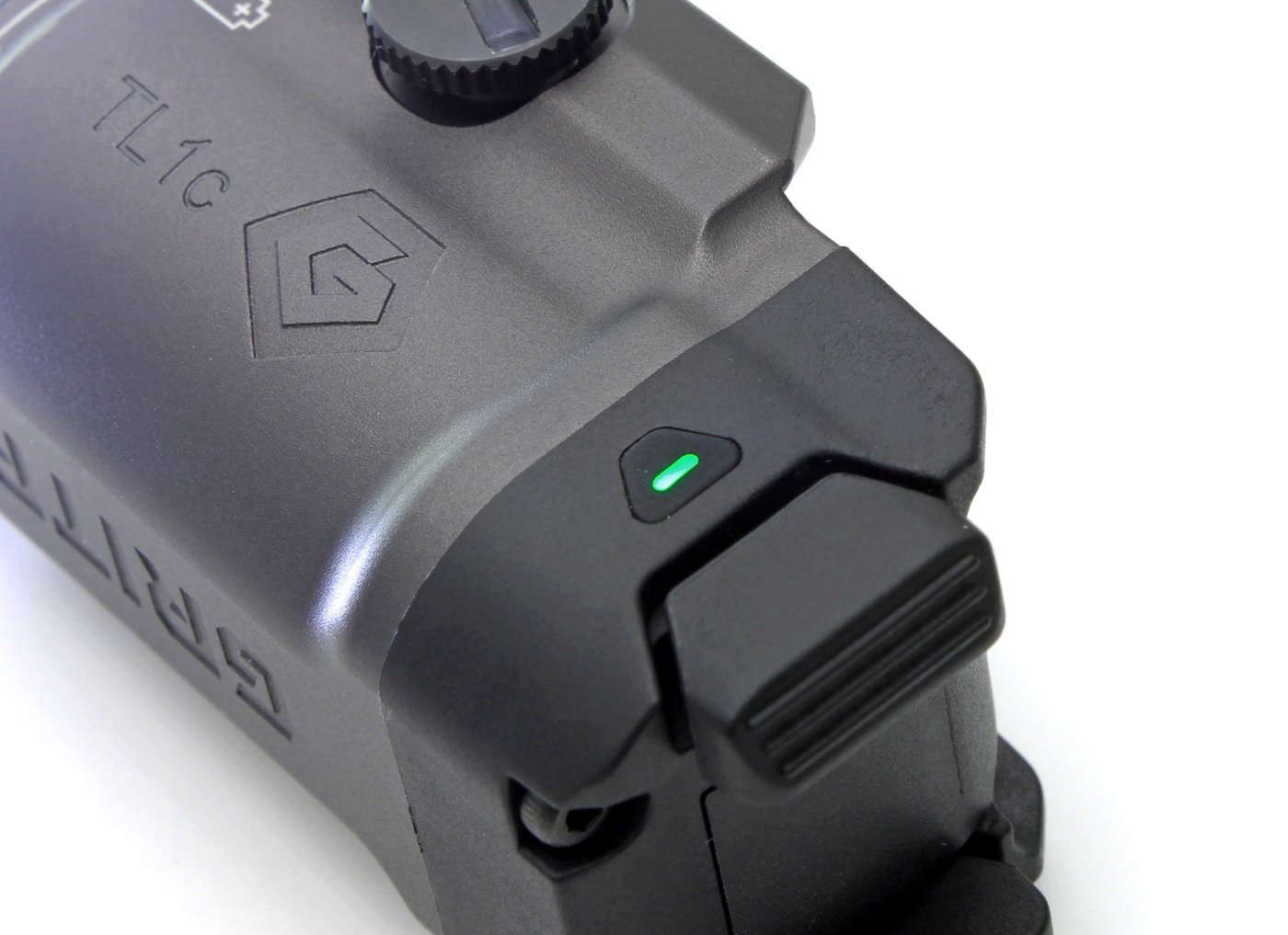 Close-up image of the GRITR TL1c Compact Weapon Light showing the illuminated battery indicator light. The indicator is a small, multicolored LED that changes color based on battery charge — green for full, blue for moderate, and red for low. This lets users check the light’s remaining power at a glance with just a single tap of the activation button. The clear, simple visual display helps prevent unexpected power loss, which is especially important in defensive or tactical situations. The light’s placement is easily visible and accessible, supporting the article’s focus on practical features. GRITR TL1c indicator light, battery status LED, weapon light power check, tactical flashlight review.