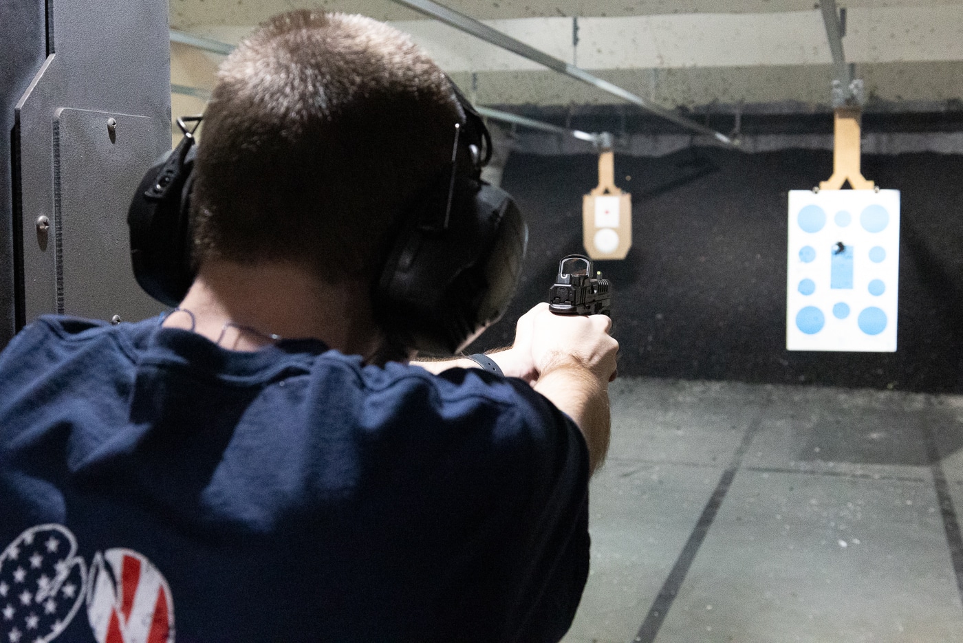 Shooter at outdoor shooting range riding the reset on Springfield Echelon pistol demonstrating proper trigger control technique where finger stays at reset threshold between rapid fire shots. Understanding trigger reset point in modern striker-fired handguns allows faster follow-up shots by minimizing trigger finger travel distance from reset to full press. Woman practices keeping continuous trigger contact at reset position rather than letting trigger return completely forward after each shot. Springfield Echelon reset characteristics provide tactile and audible feedback that tells shooter when sear has re-engaged and firearm is ready to fire again. Proper reset technique reduces movement that disrupts grip stability and sight picture.