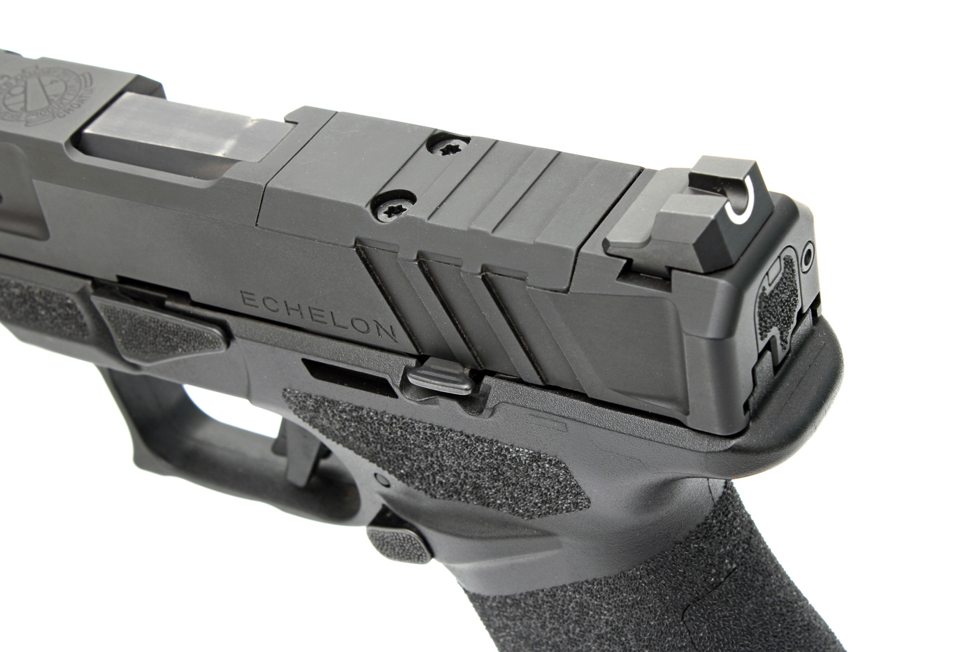 The image provides a close-up view of the slide and sights on a California-compliant Echelon pistol from Springfield Armory. The optics-ready slide cut is clearly visible, designed to accommodate a wide range of red dot optics. The photo highlights the U-Dot defensive sight system, with a prominent tritium front sight and a deep rear notch, for quick target alignment in low light or bright daylight. Serrations on the slide are present for improved grip when racking the action. The overall finish of the slide is matte and non-reflective, reducing glare during use. This close-up helps readers understand the Echelon’s focus on practical, user-friendly sighting and modern features found on California-compliant Echelon pistols.