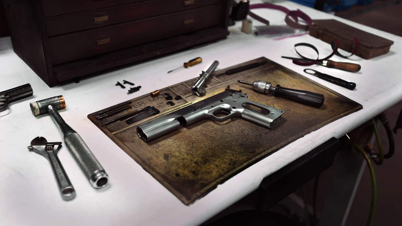 Unadorned 1911 pistol frame showing the simplicity of John Browning's original fighting handgun design for .45 ACP ammunition. The standard configuration lacks optical sight cuts, extended dust covers for weapon lights, or competition-grade trigger work. Plain models offer proven defensive capability without custom shop modifications that drive up costs significantly. The flat profile made this full-size pistol easier to carry concealed than many shooters expected. Basic 1911 pistols served Texas Rangers, military personnel, and home defenders effectively for over 100 years. Modern versions like the Springfield Armory Mil-Spec maintain reliability while feeding jacketed hollow points designed for self-defense. Simple fixed sights and standard controls provide everything needed for protection without unnecessary extras.