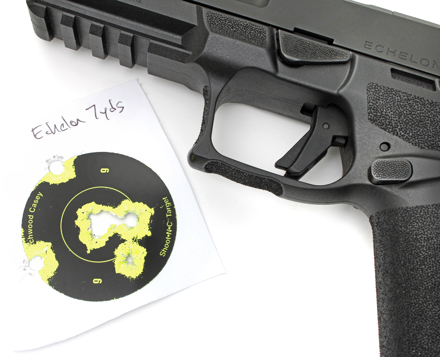 The image shows a paper target marked with multiple groups, each formed by shots fired from a California-compliant Echelon pistol using CCI Blazer 115-grain FMJ ammunition. The target displays several tight clusters of bullet holes, demonstrating the pistol’s practical accuracy at standard range distances. Each group is well-defined, with minimal spread between individual shots, showing what shooters can expect when bench testing with this popular 9mm load. The background is neutral and the target is mounted or placed for clear visibility of the hits. This photo visually supports claims in the article regarding group size and real-world accuracy of California-compliant Echelon pistols with CCI Blazer ammunition. Lighting is even, ensuring the holes and scoring zones are easily distinguishable.