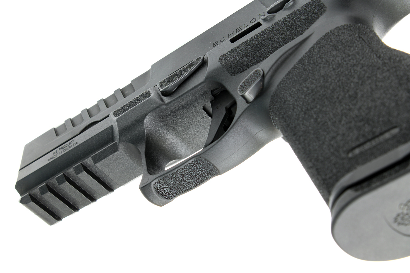 The image shows a close-up of the Adaptive Grip Texture on a California-compliant Springfield Echelon pistol, focusing on the grip area, backstrap, and parts of the frame. The fine, raised texturing is clearly visible, providing a non-slip surface to enhance control during shooting. The photograph highlights how the texture pattern extends to high-contact areas, supporting a consistent and comfortable grip regardless of hand size. This detail shot is designed to demonstrate one of the practical ergonomic features of California-compliant Echelon pistols, which helps manage recoil and promotes fast follow-up shots. The texture’s design strikes a balance between aggressive traction and everyday comfort, making the pistol suitable for both range and defensive use.