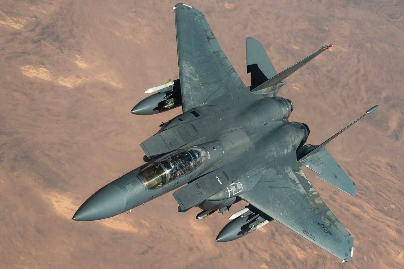 Strike Eagle F-15E dual-role fighter aircraft in flight configuration showing the robust airframe structure with aluminum honeycomb wings, titanium components, and twin Pratt Whitney turbofan engines providing thrust for air-to-air and air-to-ground combat operations. The McDonnell Douglas designed multirole fighter features wide-field-of-view heads-up display, multi-purpose CRT displays for navigation and weapons delivery, and laser gyro GPS navigation systems for precision targeting. This tactical all-weather fighter bomber can engage Soviet-designed aircraft, destroy enemy ground positions, and carry 500-pound and 2,000-pound guided munitions along with M61A1 20mm cannon ammunition. The F-15E entered service with the 4th Tactical Fighter Wing at Seymour Johnson Air Force Base and 40th Tactical Training Wing at Luke Air Force Base. Boeing acquired McDonnell Douglas and continued F-15E production through 2017 with 435 Strike Eagles and export variants manufactured. The combat-proven fighter serves in Middle East operations, Global War on Terror missions, and recent strikes against Iranian-backed militants and military facilities.