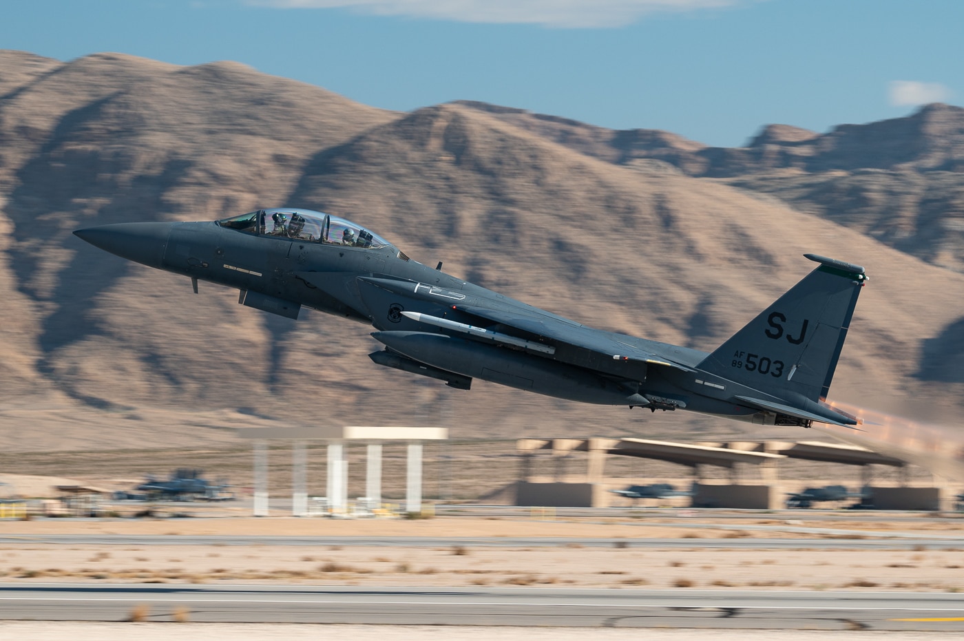 F-15E Strike Eagle tactical fighter assigned to 4th Fighter Wing based at Seymour Johnson Air Force Base North Carolina launching from Nellis Air Force Base Nevada runway during Red Flag-Nellis 24-1 exercise in January 2024. The twin-engine multirole combat aircraft features conformal fuel tanks and external weapons loadout for realistic combat training mission. Red Flag exercises provide advanced tactical training for Strike Eagle crews simulating large-scale air operations against sophisticated enemy air defenses and fighter threats. The 4th Fighter Wing received initial operational F-15E deliveries in 1988 making it one of the first combat units to fly the dual-role fighter. Seymour Johnson AFB Strike Eagles deploy regularly for combat operations in Middle East, training exercises at Nellis AFB Nevada, and homeland defense missions. The all-weather tactical fighter features Pratt Whitney F100 turbofan engines with afterburners engaged during takeoff for Red Flag mission sorties. United States Air Force uses Red Flag training to prepare F-15E crews for air-to-air combat, precision strike operations, and integrated warfare scenarios before operational deployments.