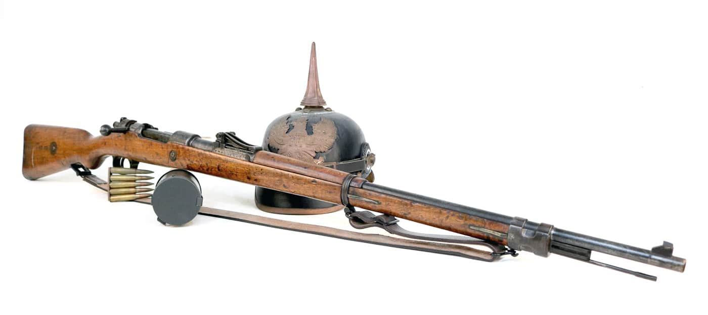 German Gewehr 98 bolt action rifle displayed in full profile showing the complete 49-inch length of this World War I era military rifle. The Gew 98 features the distinctive Mauser controlled-feed action, straight bolt handle, and 29-inch barrel that German Imperial forces used from 1898 through 1918. This 7.92x57mm Mauser rifle includes the tangent rear sight graduated to 2000 meters, wooden stock with metal buttplate, barrel bands, and the five-round internal box magazine that made the Gewehr 98 one of the most reliable military bolt rifles ever produced. The rifle's dark wood stock and blued steel finish represent typical German military manufacturing standards. This particular G98 demonstrates the craftsmanship and robust construction that influenced countless military and sporting rifles including the American M1903 Springfield, British Pattern 14, Czech Vz-24, and eventually the shortened Kar98k carbine.