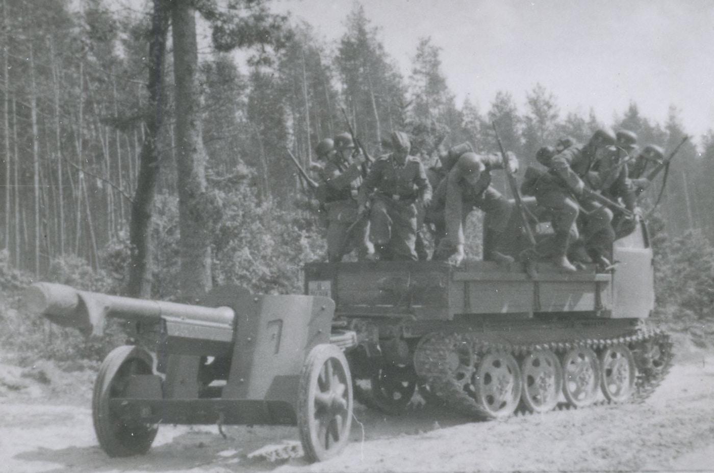 Waffen SS soldiers dismount from a tracked armored vehicle while carrying Karabiner 98k Mauser rifles during Eastern Front combat operations against Soviet forces in World War 2, demonstrating German mechanized infantry tactics that combined vehicle mobility with dismounted infantry assault. The SS troops equipped with standard Kar98k bolt-action rifles jump from the halftrack or armored personnel carrier to engage in ground combat, using the 7.92x57mm Mauser service weapon that served both Wehrmacht and Waffen SS units throughout the war from 1939 to 1945. German mechanized infantry doctrine emphasized rapid deployment from vehicles into tactical positions where soldiers would fight on foot with their individual weapons including the Karabiner 98 kurz rifle, MP40 submachine guns, and MG34 or MG42 machine guns. The Eastern Front from 1941 through 1945 saw extensive use of German halftracks, armored cars, and other vehicles to transport SS and Wehrmacht infantry across the vast distances of the Soviet Union during Operation Barbarossa and subsequent campaigns. Waffen SS units like the Leibstandarte, Das Reich, Totenkopf, and Wiking divisions operated as elite mechanized formations on the Eastern Front, equipped with vehicles for mobility but still relying on the Kar98k as the primary individual weapon for dismounted combat. The bolt-action Mauser rifle proved effective in the hands of well-trained SS troops despite being inferior to Soviet semi-automatic rifles like the SVT-40, with German emphasis on marksmanship training and fire discipline compensating for lower rate of fire. German armored vehicles provided protected transport and heavy weapons support but mechanized infantry still conducted most actual fighting dismounted on foot, using terrain, buildings, and fortifications for cover while employing rifles, machine guns, and grenades. The Karabiner 98k served Waffen SS soldiers throughout brutal Eastern Front combat including major battles at Moscow, Stalingrad, Kursk, Kharkov, and numerous other engagements where SS formations fought as shock troops and fire brigades plugging gaps in German lines against overwhelming Soviet numerical superiority.