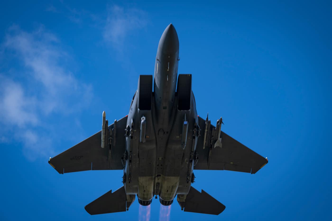 McDonnell Douglas F-15E Strike Eagle dual-role fighter aircraft departing runway with full weapons loadout including air-to-air missiles and precision-guided bombs mounted on wing pylons and fuselage stations. The twin-engine multirole combat aircraft features conformal fuel tanks attached to fuselage sides providing extended operational range for deep strike missions. Strike Eagle weapons configuration includes AIM-120 AMRAAM air-to-air missiles, AIM-9 Sidewinder infrared-guided missiles, GBU-12 laser-guided bombs weighing 500 pounds, and GBU-31 GPS-guided bombs weighing 2,000 pounds. The F-15E airframe can carry up to 11 tons of ordnance across multiple hardpoints while maintaining air-to-air combat capability. Pratt Whitney F100-PW-229 turbofan engines provide thrust for takeoff with heavy weapons loads and fuel for long-range tactical fighter missions. United States Air Force Strike Eagles employ mixed loadouts when conducting operations requiring both air superiority and ground attack capabilities during missions in Iraq, Afghanistan, Syria, and Libya.