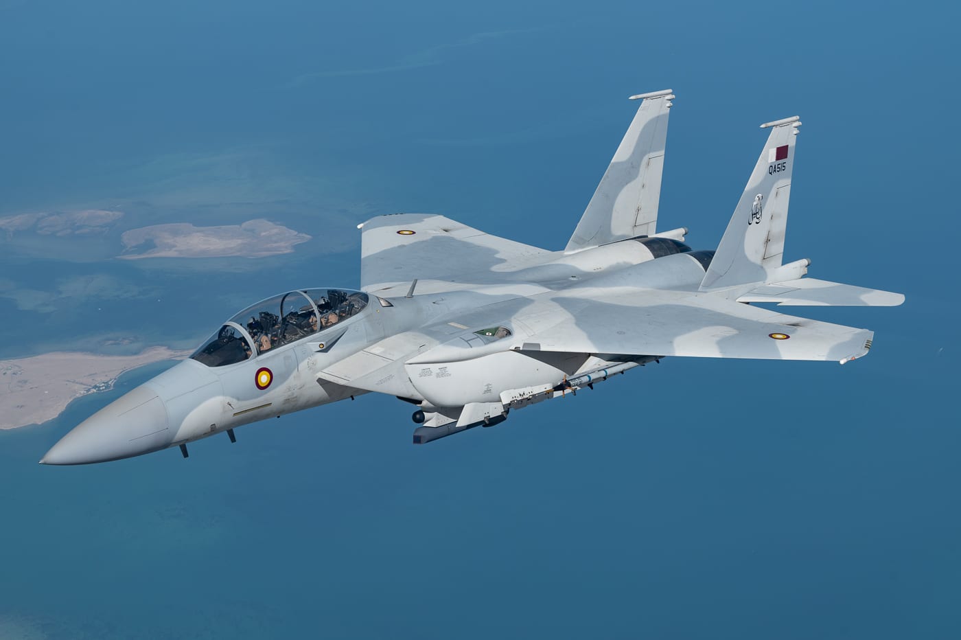 Qatar Emiri Air Force F-15E Strike Eagle multirole fighter aircraft flying during Exercise Sky Shield multinational training operations demonstrating air defense and strike capabilities. The twin-engine tactical fighter features distinctive desert camouflage paint scheme and Qatar national markings on fuselage and vertical stabilizers. Strike Eagle export variants serve with multiple allied nations including Royal Saudi Air Force F-15SA, Israeli Air Force F-15I Ra'am, Republic of Korea Air Force F-15K Slam Eagle, and Republic of Singapore Air Force F-15SG models. The F-15E platform provides Qatar with advanced air-to-air and air-to-ground combat capabilities including AESA radar systems, precision-guided munitions delivery, and electronic warfare suites. Boeing manufactures F-15 variants for foreign military sales through U.S. State Department approved programs enhancing regional security partnerships. Qatar's Strike Eagles participate in coalition exercises with United States Air Force, NATO allies, and Gulf Cooperation Council partners to practice integrated air operations and combat tactics.