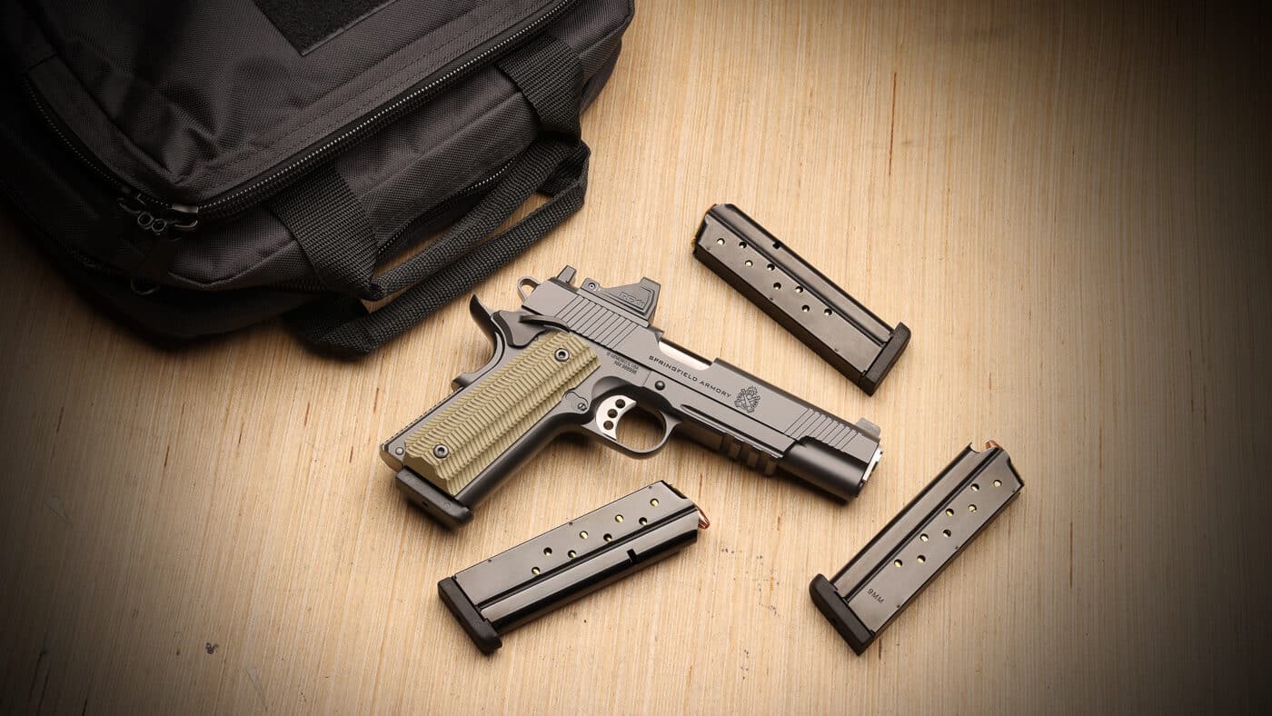 Springfield Armory 1911 Operator Gear Pac bundle showing tactical single-action pistol with integrated accessory rail, factory-installed Viridian RFX11 green dot reflex sight, and four magazines. The Operator 1911 Gear Pac configuration combines Springfield's enhanced tactical platform with modern optic-ready capability, AOS A12B mounting plate, pre-installed reflex sight, and protective carrying case worth up to $375. Springfield tactical 1911 pistol with Gear Pac accessories delivers classic single-action design enhanced with accessory rail for weapon-mounted lights and contemporary green dot sight offering 3 MOA reticle. Factory-equipped Operator 1911 includes four magazines providing ammunition capacity for defensive applications, range training sessions, and reload practice drills with rail-equipped tactical platform. Gear Pac Operator configuration features AOS mounting system allowing secure optic installation while maintaining co-witness capability with iron sights through RFX11 reflex sight window. Springfield tactical 1911 platform with factory-mounted green dot eliminates post-purchase optic installation delivering ready-to-shoot enhanced pistol combining heritage design with modern defensive features. Operator 1911 Gear Pac bundle includes slide cover plate with integral rear sight allowing shooters to remove optic and utilize traditional iron sight configuration. Springfield rail-equipped classic pistol with complete accessory package represents permanent catalog offering available through authorized dealers without limited-time restrictions.