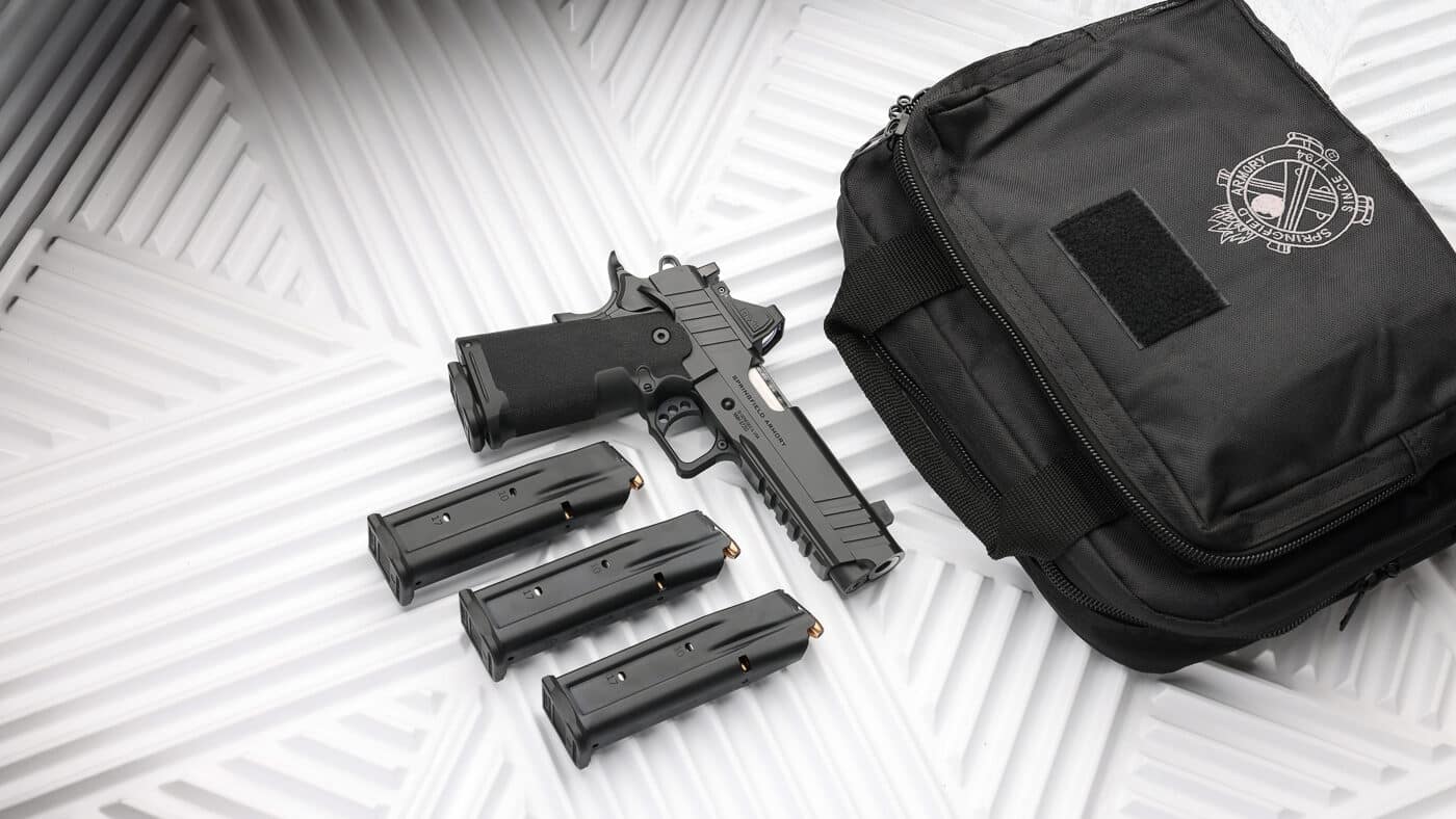 Springfield Armory pistol displayed with complete Gear Pac accessory bundle including Viridian green dot optic system, multiple spare magazines, and protective gun bag for secure firearm storage. The Gear Pac program from Springfield Armory delivers optic-ready pistols with factory-installed RFX11 reflex sight, four high-quality magazines for extended shooting sessions, and durable carrying case as permanent catalog offering rather than limited-time promotion. Bundled handgun package eliminates need to purchase complementary goods separately, saving shooters several hundred dollars on essential pistol accessories typically acquired alongside new firearm. Green dot sight technology offers advantages over red dot alternatives with better visibility across varying light conditions and reduced eye strain during extended use. Four-magazine configuration supports both defensive applications requiring backup ammunition capacity and training scenarios demanding multiple pre-loaded magazines for reload practice drills. Included pistol bag provides organized storage solution with room for firearm, magazines, ammunition, and other shooting range essentials while maintaining security through lockable zipper system.