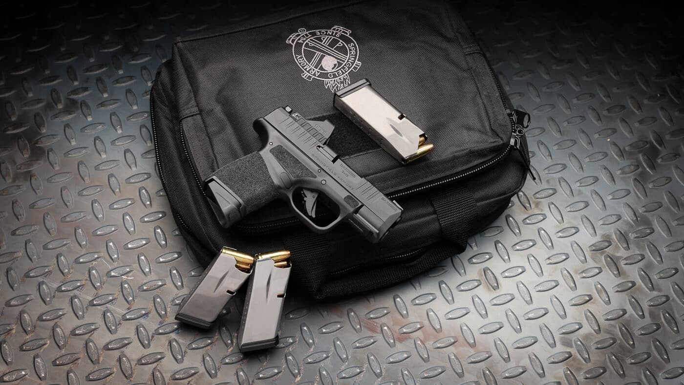 Springfield Armory Hellcat Gear Pac micro-compact pistol with factory-installed Viridian RFX11 green dot reflex sight featuring matching slide serrations for integrated appearance. The Hellcat Gear Pac bundle includes Springfield's popular concealed carry pistol with pre-mounted optic, four high-capacity magazines, and protective carrying case delivering complete defensive handgun package. Springfield Hellcat pistol in Gear Pac configuration combines micro-compact dimensions ideal for everyday carry with factory-equipped green dot sight eliminating post-purchase optic installation. Viridian RFX11 reflex sight on Hellcat features serrations and grooves matching pistol slide cuts creating seamless cosmetic integration and additional grasping surface for slide manipulation. Hellcat Gear Pac accessories include four magazines providing ammunition capacity for concealed carry rotation, backup defensive capability, and training applications at shooting range. Factory-mounted green dot optic offers 3 MOA reticle with Instant-On technology, ambient light sensor, and extended 30,000-hour battery runtime from compact CR2032 power source. Springfield micro-compact carry gun with complete accessory bundle represents permanent catalog offering saving shooters up to $375 on complementary goods typically purchased separately. Hellcat Gear Pac configuration delivers optic-ready defensive pistol with co-witness iron sight capability and included slide cover plate for traditional sighting option.