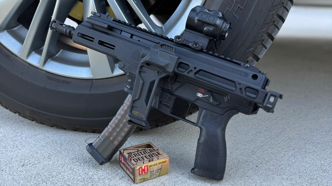 Springfield Armory Kuna pistol with box of ammo next to truck wheel