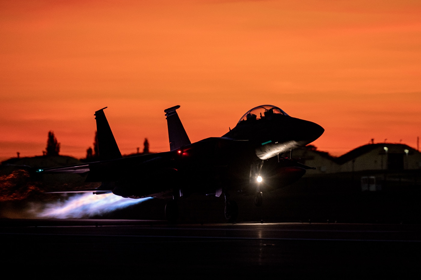 United States Air Force F-15E Strike Eagle tactical fighter launching from Royal Air Force Lakenheath England runway at dusk for NATO training exercise demonstrating twilight operations capability. The twin-engine multirole combat aircraft features afterburners illuminated during takeoff with 48th Fighter Wing markings visible on fuselage. RAF Lakenheath serves as only permanent U.S. Air Force Strike Eagle base in Europe providing forward-deployed combat capability for NATO operations and European security missions. The all-weather tactical fighter operates from England supporting training exercises with Royal Air Force, German Luftwaffe, French Air Force, and other allied nations. F-15E Strike Eagles at Lakenheath received EPAWSS electronic warfare systems in January 2025 making them first active duty aircraft with advanced Eagle Passive Active Warning and Survivability System. The 48th Fighter Wing conducts air-to-air and air-to-ground training missions across European airspace maintaining combat readiness for contingency operations. Strike Eagles deploy from RAF Lakenheath for operations in Middle East, Baltic air policing missions, and NATO exercises like Red Flag-Alaska and Atlantic Trident.