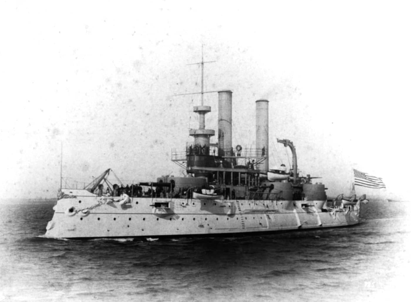 USS Iowa BB-4 United States battleship photographed during her service years, representing a unique one-off design in American pre-dreadnought battleship development rather than serving as the lead vessel of a battleship class. Commissioned in 1897, this American battleship incorporated critical design improvements over the problematic Indiana-class vessels, specifically addressing the inadequate belt armor and poor seakeeping qualities that plagued earlier United States battleships. The USS Iowa BB-4 was purposefully designed as an ocean-going battleship capable of operating in open waters, marking an important evolution in U.S. Navy battleship philosophy from coastal defense to true power projection. This pre-dreadnought warship featured mixed-caliber armament typical of all American battleships built before the dreadnought revolution transformed naval warfare with uniform all-big-gun batteries starting in 1906. The vessel's design represented the United States Navy's learning process as American shipbuilders and naval architects gained experience constructing competitive battleships that could match foreign capital ships. USS Iowa BB-4 served during the Spanish-American War alongside other pre-dreadnought battleships including the Indiana-class vessels, demonstrating improved capabilities in combat operations. The photograph shows the characteristic pre-dreadnought features including multiple funnels, heavy military masts, mixed gun batteries, and the substantial freeboard necessary for ocean operations. As a transitional design between the flawed Indiana-class coastal defense battleships and subsequent improved pre-dreadnought classes, the USS Iowa BB-4 represents an important stepping stone in American battleship evolution toward the mighty dreadnoughts and fast battleships that would eventually dominate the seas.