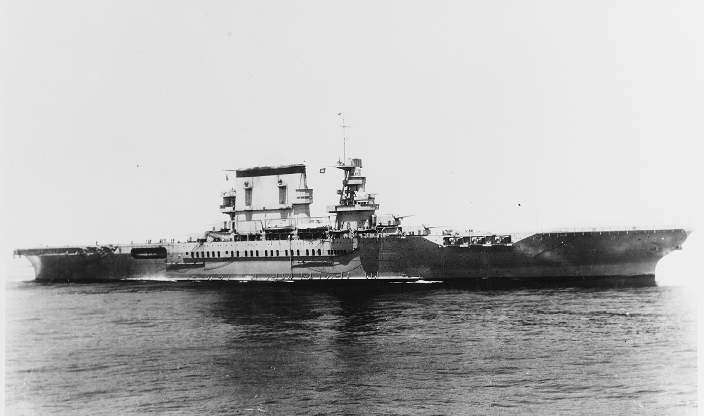 USS Lexington CV-2 underway at sea showing the massive converted battlecruiser-turned-aircraft carrier that served the United States Navy during early World War II Pacific operations. Lady Lex featured a 901-foot flight deck that was 100 feet wide operating with 86 aircraft including fighters, dive bombers, and torpedo planes. The Lexington aircraft carrier CV-2 was one of two Lexington-class carriers built under the Washington Naval Treaty after the battlecruiser construction program was canceled in the early 1920s. USS Lexington displaced 36,000 tons on the converted battlecruiser hull and was armed with eight 8-inch guns and twelve 5-inch anti-aircraft guns when commissioned in late 1927. This flattop participated in critical Pacific engagements including operations after Pearl Harbor, attempted Wake Island relief, raids on Rabaul, and the historic Battle of Coral Sea in May 1942. Lady Lex and sister ship Saratoga CV-3 were the largest aircraft carriers in the world when commissioned, pioneering carrier aviation tactics during 1930s naval exercises. USS Lexington CV-2 earned two battle stars before being lost at the Battle of Coral Sea on May 8, 1942, becoming the first American fleet carrier sunk in World War II.