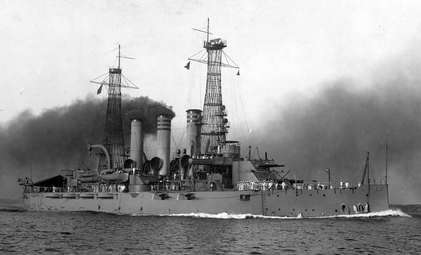 USS Virginia BB-13 United States battleship underway with the distinctive flawed stacked turret design clearly visible, representing the Virginia-class pre-dreadnought battleships that became the most prolific American battleship series built to that point. The Virginia-class consisted of five vessels: USS Virginia BB-13, USS Nebraska BB-14, USS Georgia BB-15, USS New Jersey BB-16, and USS Rhode Island BB-17, all featuring problematic two-story turret arrangements similar to the earlier Kearsarge-class battleships. These American battleships incorporated stacked turrets with 12-inch main guns in the lower turret and 8-inch guns mounted above, but unlike earlier designs, the upper 8-inch guns were unable to fire independently from the main 12-inch guns, creating severe tactical limitations. The photograph clearly shows USS Virginia BB-13's unique turret configuration that made these pre-dreadnought battleships obsolete at their commissioning despite being the newest vessels in the United States Navy fleet. Prior to World War I, the Virginia-class battleships saw duty in Central and South America during police actions where American naval power supported diplomatic objectives, but their use was extremely limited during the Great War due to their outdated design. All five Virginia-class vessels were disposed of in 1923, with two ships sunk and three scrapped, victims of both their flawed design and the Washington Naval Treaty that limited United States battleship strength. The image captures the distinctive stacked turret arrangement that defined the Virginia-class and demonstrates how experimental pre-dreadnought battleship designs sometimes incorporated features that reduced rather than enhanced combat effectiveness. As the most numerous pre-dreadnought battleship class built by America, the Virginia-class represents both the United States Navy's expanding industrial capacity and the design missteps that occurred before the dreadnought revolution standardized battleship architecture with uniform all-big-gun batteries and conventional turret layouts.