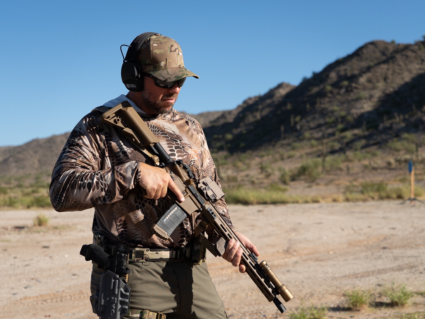 Author demonstrating preparation phase of top three shooting drills on professional firearms training range before executing dynamic movement exercise. Best shooting drills for skill development combine static accuracy work with running gun techniques and tactical movement patterns. Shooter ready position on range shows proper stance before beginning timed pistol drill that tests multiple marksmanship fundamentals simultaneously. Effective firearms training drills incorporate draw presentation, target transitions, reload procedures, and recoil control techniques in single exercises. Top shooting practice drills merge competitive shooting speed methods with defensive tactics training for well-rounded gun handling proficiency. Range setup for movement-based shooting exercises demonstrates professional approach to firearms skill building through structured practice sessions. Instructor preparing dynamic shooting drill that includes distance changes, magazine exchanges, and elevated heart rate conditions for realistic training. Comprehensive shooting drills work essential skills from holster draw through final shot placement while building speed and maintaining accuracy standards.