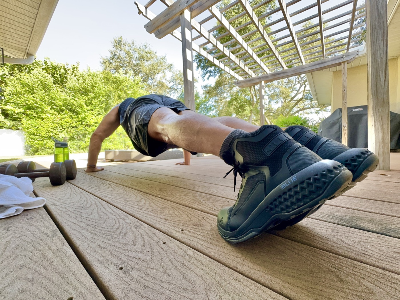 Experienced patrol officer wearing Rocky Code Blue Public Service boots during outdoor field testing showing practical law enforcement tactical footwear application for police duty. Rocky Boots six-inch non-metallic patrol boots worn by author with 12,000 miles on-duty experience evaluating comfort support and durability for public safety professionals. Police tactical boots with fiberglass shank and EVA Rebound midsole shown in use providing shock absorption during circuit training exercises and outdoor activities. Black duty boots featuring breathable construction and TPU overlay panels worn during testing that included traversing drainage ditches scrub terrain and chain-link fence climbing. Law enforcement officer demonstrating Rocky Code Blue boot performance showing adequate ankle protection from six-inch height without excessive bulk of traditional eight-inch patrol boots. Budget tactical footwear under $98 MSRP worn by police professional showing presentable appearance suitable for city hall meetings while handling field work requirements. Rocky public service boots tested through Circuit of Doom workout regimen including burpees lunges high knees and various push-ups accelerating typical patrol boot wear patterns. Non-waterproof breathable patrol boots worn in Florida climate conditions showing practical alternative to heat-trapping waterproof boot designs for warm weather law enforcement duty.