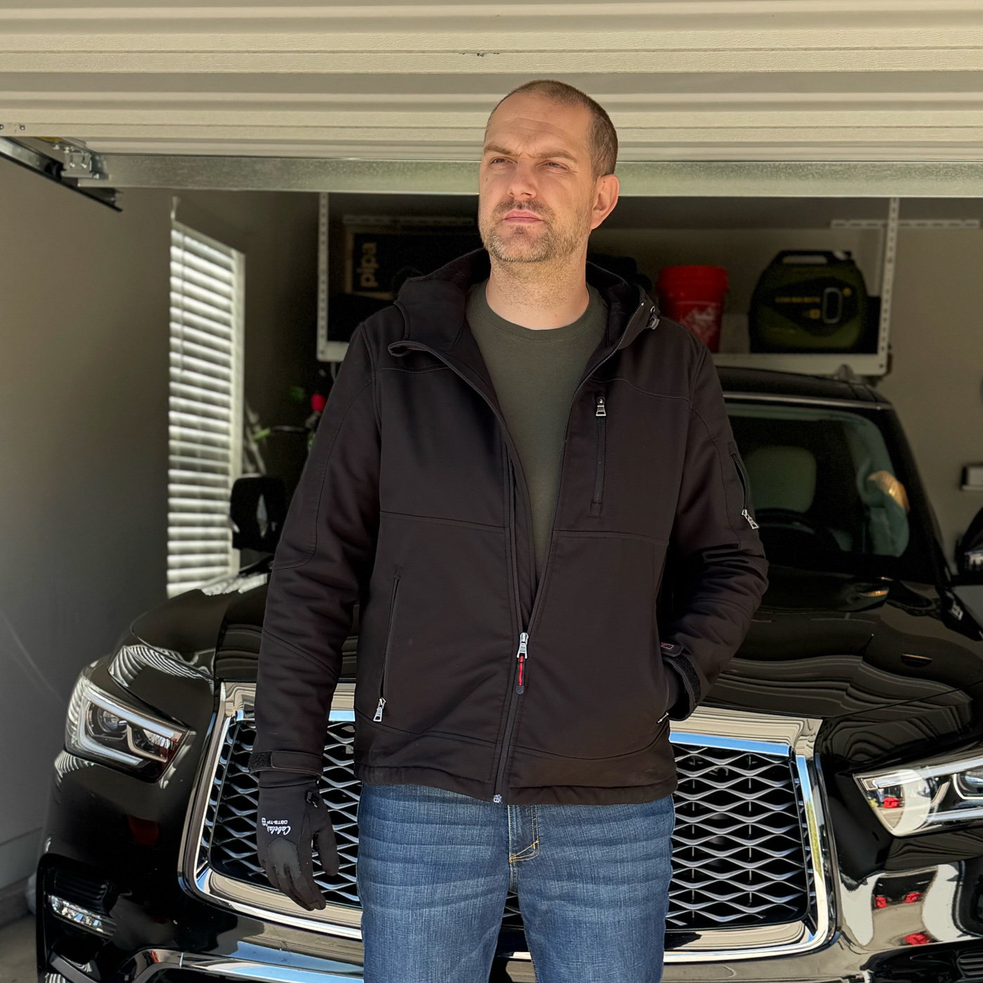 Man wearing lightweight winter coat or CCW jacket with one hand inserted in coat pocket illustrating common cold weather habit that compromises quick access to concealed carry firearm and increases draw time during threat scenarios. Photo demonstrates tactical vulnerability of pocket carry hand positioning showing how natural cold weather behavior conflicts with defensive readiness principles for armed citizens carrying concealed firearms beneath cover garments. Concealed carrier in light winter jacket from brands like 5.11 Tactical or Vertx with hand in pocket revealing accessibility challenges that winter clothing habits introduce to situational awareness and rapid presentation from IWB or OWB holster positions. Image shows everyday carry posture during cold weather conditions highlighting why concealed carry training must address hand positioning and garment sweep techniques when wearing insulated jackets or heavy coats that tempt carriers to keep hands warm in pockets. Winter concealed carry setup with shooter demonstrating relaxed stance and pocket hand placement that would delay establishing combat grip and master grip acquisition if defensive scenario required immediate draw stroke from appendix carry or strong side holster. Man in cold weather jacket showing tactical consideration of hand placement outside pockets for maintaining reduced reaction time and quick access to holstered pistol whether carrying Glock, Springfield Armory, Sig Sauer, or Smith & Wesson firearms beneath winter layers. Concealed carry lifestyle photo illustrating balance between comfort in freezing temperatures and maintaining defensive capability showing why EDC practitioners must develop muscle memory for keeping dominant hand free and accessible near holster location at 3 o'clock or 4 o'clock position even when cold conditions encourage pocket warming behavior.