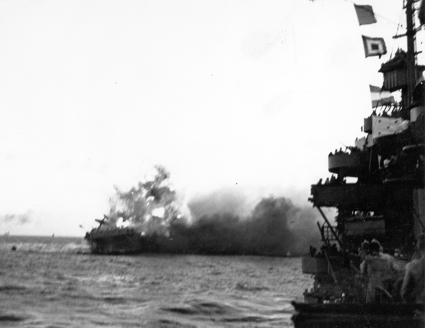 Massive explosion rocking USS Lexington CV-2 and blowing aircraft off the flight deck during the Battle of Coral Sea on May 8, 1942. Lady Lex suffered catastrophic internal explosions after being struck by two Japanese Type 91 torpedoes and multiple aerial bombs during morning attacks. The Lexington aircraft carrier crew fought uncontrollable fires throughout the day before cascading explosions from detonating ordnance made abandoning ship necessary. USS Lexington CV-2 explosions ignited aviation fuel and torpedo warheads stored in the hangar deck of the converted Lexington-class battlecruiser carrier. Internal detonations knocked out engine room ventilators and threatened to destroy the entire 36,000-ton flattop displacing warplanes from the 901-foot flight deck. The Lexington carrier had been operating 86 aircraft when Japanese attacks crippled the converted battlecruiser during the first major carrier-versus-carrier engagement. Captain Frederick C. Sherman ordered abandon ship after Admiral Aubrey Fitch determined USS Lexington couldn't be saved despite hours of damage control efforts. More than 300 crew members evacuated Lady Lex with every survivor rescued though 216 sailors had been killed during the attacks.