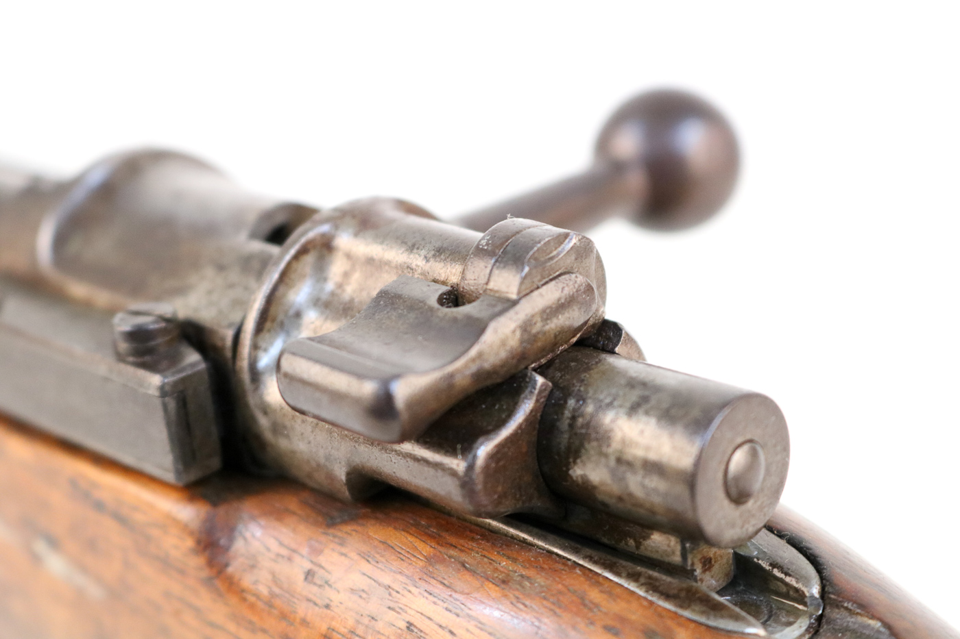 Close-up photograph of three-position flag-style safety tab on rear of Gewehr 98 bolt showing accessible manual safety mechanism that German soldiers could easily operate during World War I combat with the 7.92x57mm Mauser bolt-action rifle. The Gew 98 safety features simple tab design with left position for fire, right position locking both bolt and firing mechanism, and up position locking firing pin while allowing bolt to open for unloading without disengaging firing mechanism safety. This easy-to-access safety on German Gewehr 98 rifle provided Imperial German infantrymen with intuitive control over weapon status that soldiers including Adolf Hitler and millions of troops could manipulate quickly even with cold wet hands or while wearing gloves in trenches during 1914-1918 Great War. The three-position flag safety on Mauser G98 bolt-action rifle demonstrates practical German engineering allowing flexible carry options where soldiers could keep rifle loaded safely while maintaining ability to bring weapon into action rapidly during trench warfare combat operations.