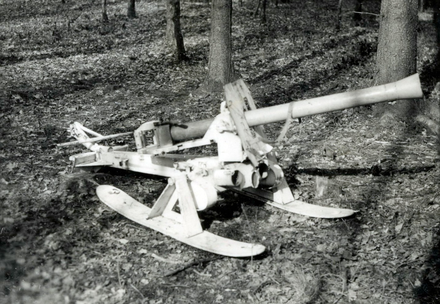 An 8.8cm Raketenwerfer 43 Püppchen is shown mounted on wooden skis instead of its standard wheeled carriage, configured for winter combat operations in snow. The Püppchen could use ski mounts for snow travel. German forces adapted weapons for winter warfare. The Raketenwerfer 43 featured quick-disconnect wheels. Ski-mounted launchers had an extremely low profile. Wehrmacht troops towed the Püppchen across snow. The skis measured 54 inches long. German anti-tank crews operated in winter conditions. Iron rings attached tow ropes to the skis.