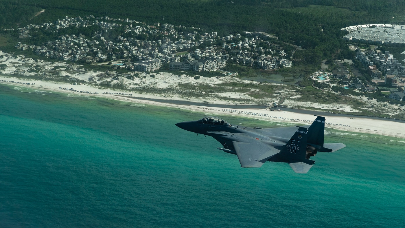 An F-15EX Eagle II conducts a test flight along the north Florida beaches, the twin-engine fighter soaring over turquoise waters and white sand during evaluation operations based out of Eglin Air Force Base. Coastal test routes provide varied flight conditions. The Eagle II evaluates performance over water and land. Eglin AFB sits near the Florida Gulf coastline. Pilots assess aircraft handling along beach corridors. The F-15EX flies test patterns over the Gulf region. North Florida offers ideal testing airspace. Boeing monitors flight data from coastal sorties. Beach overflights demonstrate low-altitude capabilities.