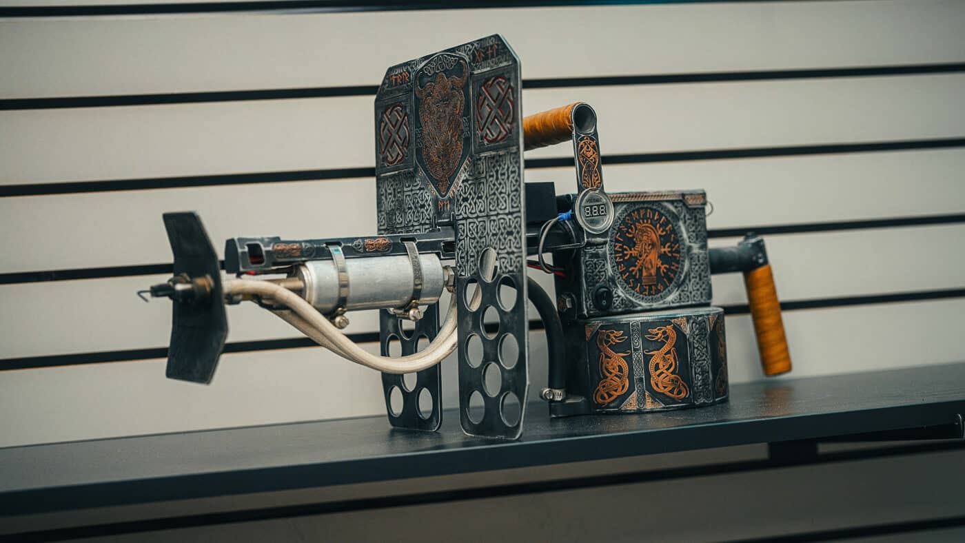 A flamethrower device features custom Cerakote finishing with decorative patterns and protective coating applied by professional finishing specialists. The Koted interview explores diverse project types. Koted Custom Finishings handles non-firearm applications. Interview of Koted discusses cross-industry demand growth. Cerakote protects various metal surfaces. Koted interview reveals unconventional custom projects. Finishing chemistry works across product categories. The interview of Koted covers market diversification strategy. Koted applies firearms expertise to new industries.