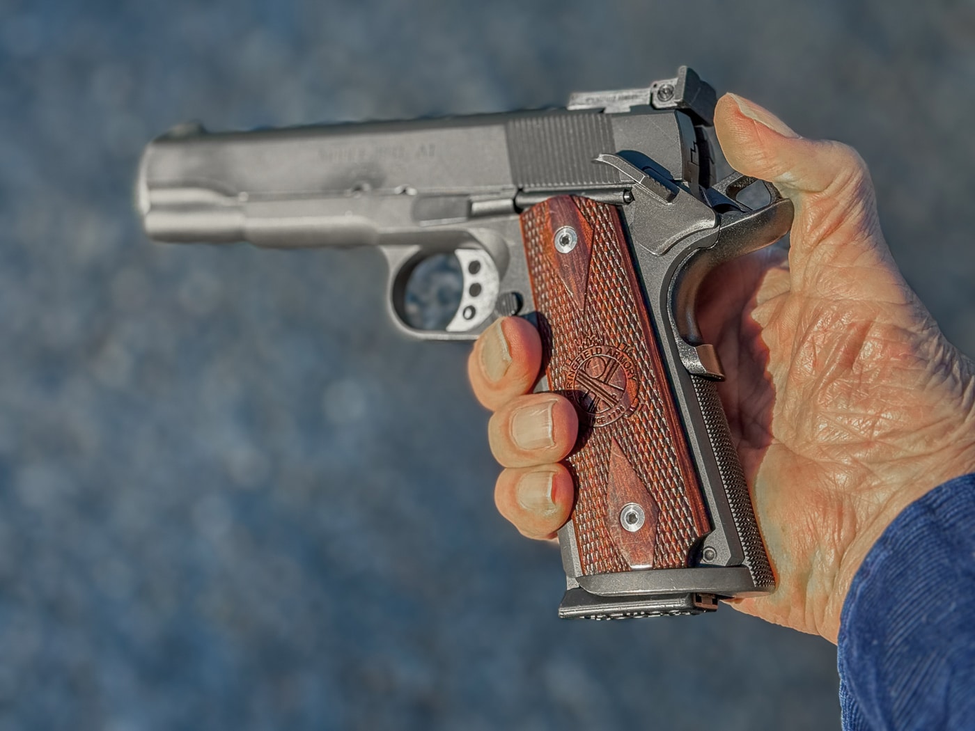 A demonstration photograph shows a thumb positioned on the cocked hammer of a 1911 pistol during the holstering process. The 1911 pistol's strengths include multiple integrated safety mechanisms. Grip safeties deactivate when palming the firearm. Thumb placement on hammers prevents accidental discharges. Safe holstering procedures require conscious deliberate actions. The 1911 pistol's weaknesses demand proper handling protocols. Trigger guard obstructions create negligent discharge risks. Engaging thumb safeties before holstering prevents problems. Expert instructors teach defensive holstering techniques.