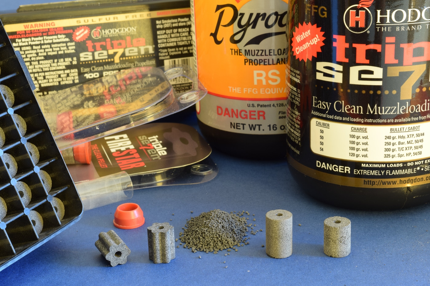 A photograph shows Pyrodex products including containers of loose granular powder and pre-formed pellets, designed as a black powder substitute for muzzleloading firearms that produces less fouling and corrosive residue. Gunpowder history includes modern substitute development. Pyrodex weighs seventy percent of black powder. Origins of gunpowder alternatives addressed cleanliness issues. Hodgdon introduced Pyrodex for muzzleloaders. Black powder substitutes measure volumetrically equal. Gunpowder origins evolved beyond traditional formulations. Pellets simplify the loading process. Modern propellants reduce barrel corrosion.